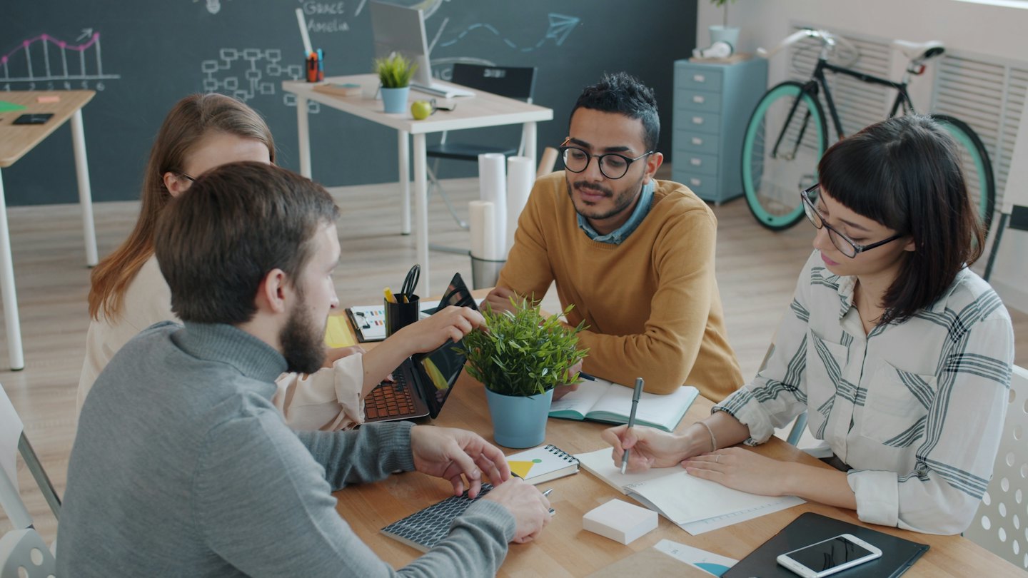 Diverse professionals brainstorming ideas around a modern office table.